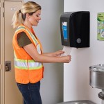 Worker taking towels from dispenser