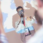 Male presenter in front of projected image