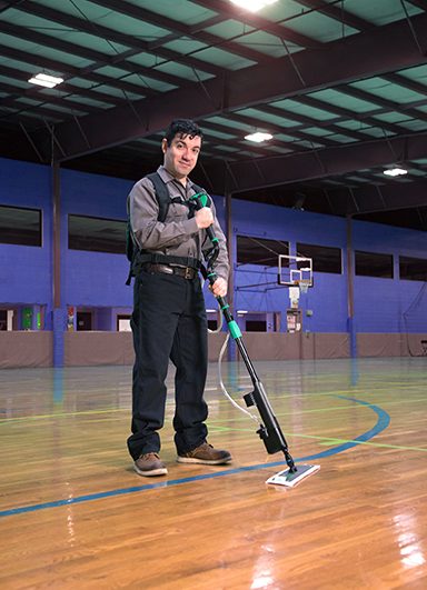 Man using Unger Excella floor-cleaning system on a gym floor