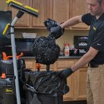 Worker vacuuming the air out a trash bag