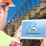 Man holding device with BuildingIQ's BMS cloud integration software in front of building