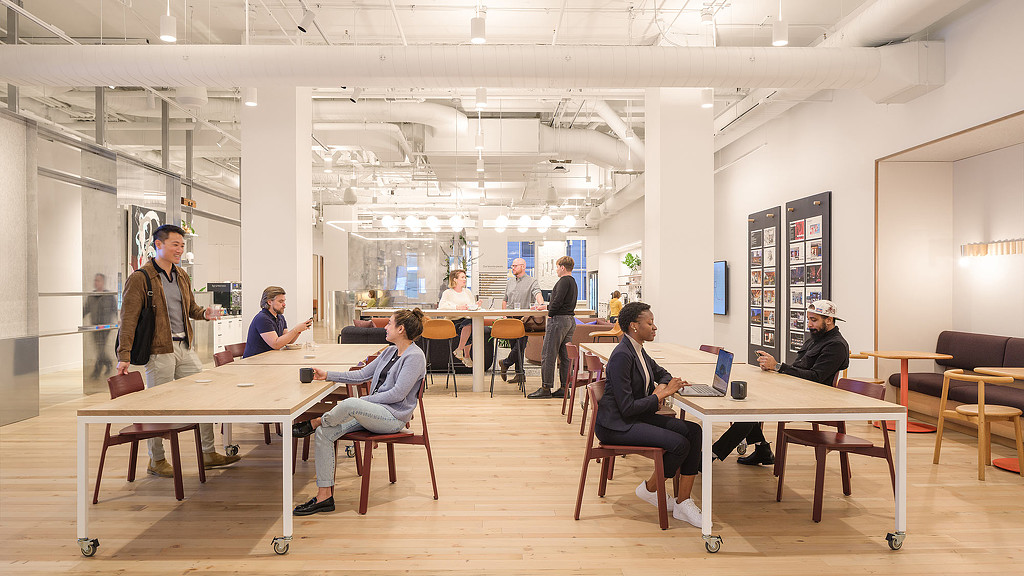 Gensler San Francisco office with people at rolling tables, bright lighting and gathering spaces, to illustrate the workplace experience