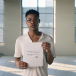 Young Black man holding a sign explaining the need for inclusive hygiene