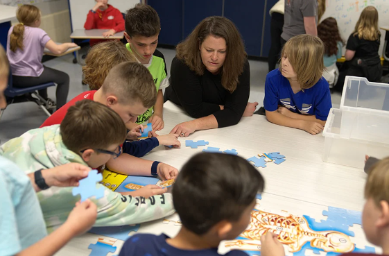 Teacher and children at table, illustrating KI’s Classroom Furniture Giveaway