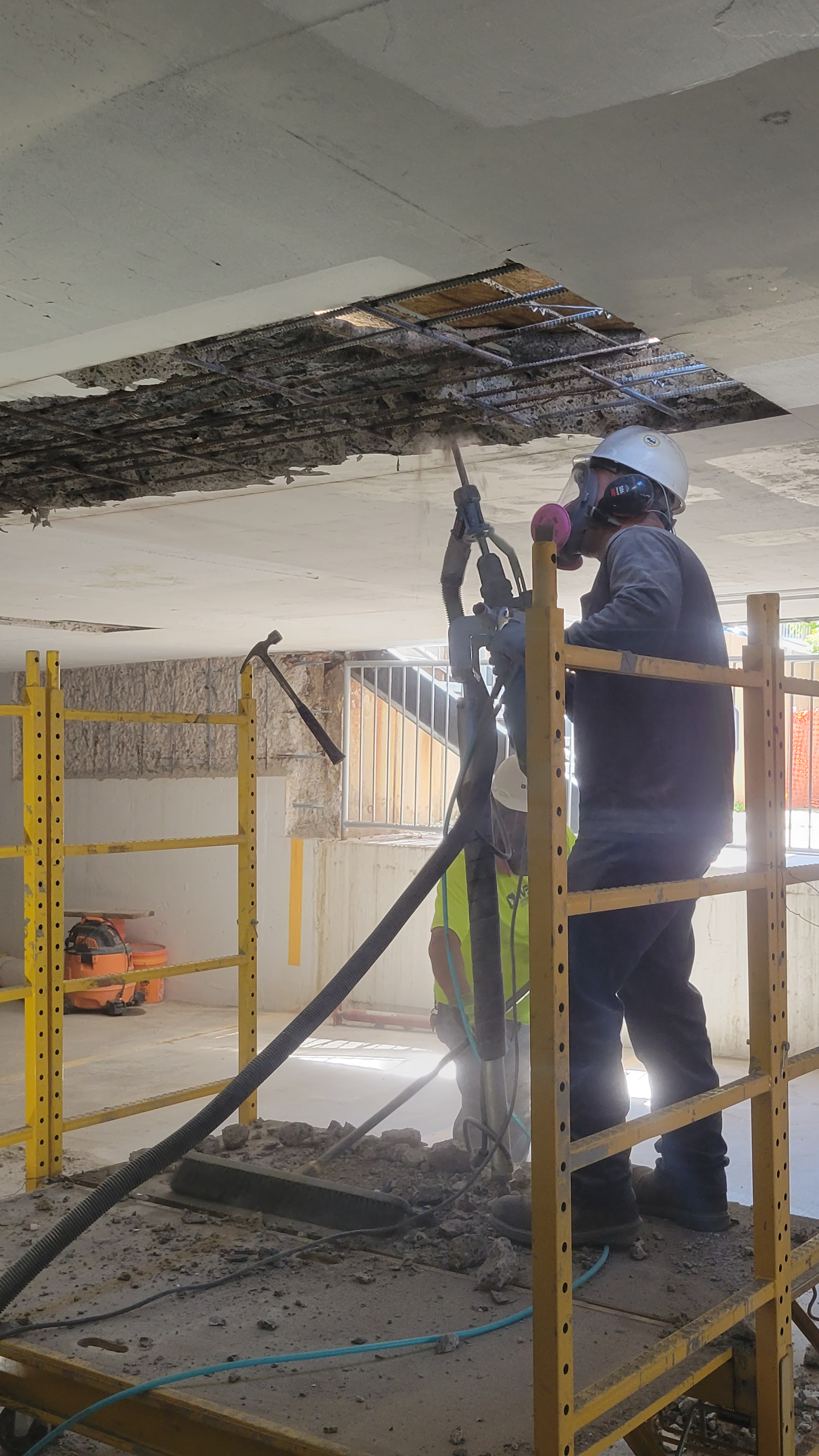 WSC workers repairing parking garage ceiling on scaffolding